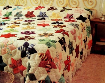 May include: A crocheted blanket with a star pattern in various colors, including red, pink, green, blue, and yellow. The blanket is made of white yarn with colorful stars. The blanket is on a bed with a wooden headboard.