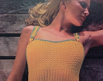 May include: A mustard yellow one-piece swimsuit featuring a textured crochet knit pattern, a straight neckline, and thick shoulder straps with teal and yellow striped detailing. The text TheSweetestCrochetPT is printed in black on the lower left side.