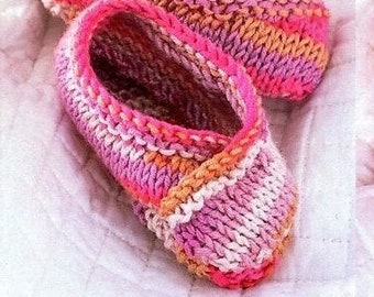 May include: A pair of hand-knitted slippers featuring a variegated yarn pattern in shades of bright pink, soft orange, and cream. The slippers have a rounded toe, a low-cut opening, and a thick, textured knit construction with a distinct ribbed edge.