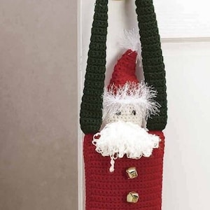 May include: A handmade crochet Santa Claus door hanger. The Santa figure has a red body with gold-colored bells, a white beard, and a red hat. The legs are striped black and white, and the feet are black. The door hanger is green.