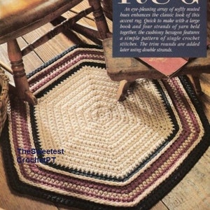 Puede incluir: Una alfombra tejida a crochet con forma hexagonal y un borde multicolor. La alfombra está hecha con hilo beige, azul oscuro y burdeos. La alfombra está sobre un suelo de madera. El texto "so-easy RUG" es visible en la imagen.