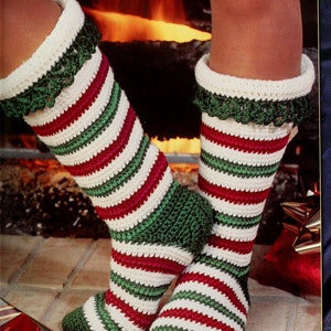 May include: A pair of crocheted Christmas stockings in red, white and green with a white background. The stockings have a crocheted lace trim.