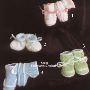 May include: An assortment of handmade baby booties in various colors. The image features four pairs of knitted booties: white with pink accents, white with blue accents, green with white accents, and light blue with white accents. Some booties have ribbon ties.