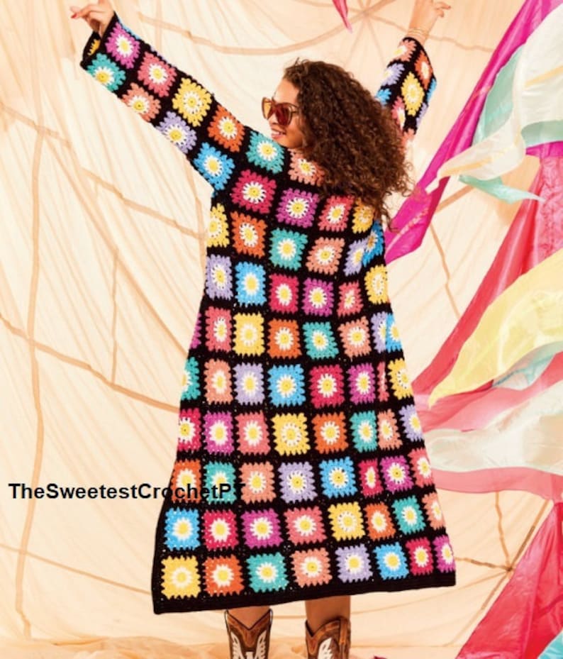 Pu&ograve; includere: Un lungo cardigan in crochet nero con un motivo di margherite colorate. Il cardigan &egrave; realizzato con un punto a quadrato della nonna e presenta una variet&agrave; di colori, tra cui rosa, blu, giallo e verde.