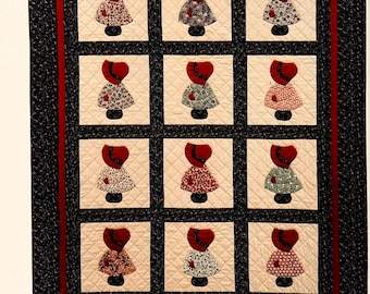 Puede incluir: Un bloque de colcha con fondo negro y borde rojo. El bloque presenta 12 figuras aplicadas de mujeres con gorros rojos y vestidos con estampados florales. El texto "Shop: TheSweetestCrochetPT" está en la parte inferior del bloque.