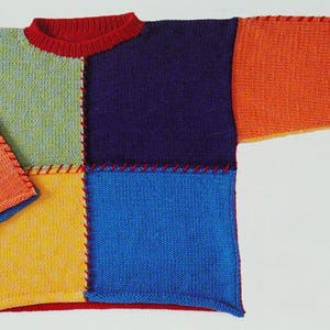 May include: A colourful knitted jumper with a patchwork design. The jumper is made of different coloured squares of yarn, including orange, yellow, green, blue, and purple. The seams are visible and are a contrasting red colour.