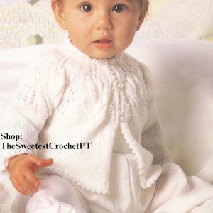 May include: A baby wearing a white knitted cardigan and matching pants. The cardigan has a delicate pattern and button closure. The baby's height is 18-20 inches (46-51 cm). Shop: TheSweetestCrochetPT.