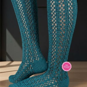 May include: A pair of teal knee-high socks featuring an openwork crochet pattern with a solid heel and toe section. A small pink circular label on the side displays the text Shop: TheSweetestCrochetPT in white lettering against a dark background.