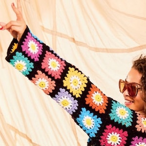 Pu&ograve; includere: Un top in crochet nero con quadrati colorati a forma di margherita. Il top ha maniche lunghe e una vestibilit&agrave; comoda.