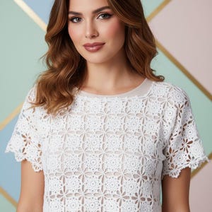 May include: A white crochet top with a floral pattern. The short-sleeved shirt has a round neckline and a delicate, openwork design. The text "Shop: TheSweetestCrochetPT" is visible in the image.