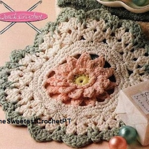 Op de afbeelding: Handgemaakte gehaakte doily met een bloemenontwerp. De doily heeft een centrale bloem in perzik- en geeltinten, omringd door crème en groen haakwerk. De tekst "Quick Crochet" en "The Sweetest Crochet PT" zijn zichtbaar.