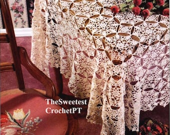May include: An off-white, intricate crochet tablecloth featuring a repeating circular and floral motif pattern that drapes over a table. The text TheSweetest CrochetPT is visible on the image. The design consists of interconnected lace elements.