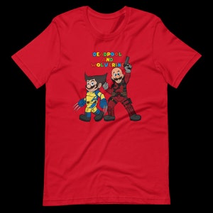 May include: Red t-shirt with a graphic of Deadpool and Wolverine in a comic book style. The text "DEADPOOL AND WOLVERINE" is printed in rainbow colors above the characters.