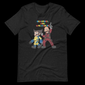 May include: A dark heather grey t-shirt with a graphic print of Deadpool and Wolverine in a cartoon style. The text "DEADPOOL AND WOLVERINE" is printed in rainbow colors above the characters.