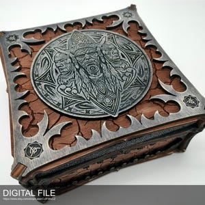Op de afbeelding: Vierkante houten kist met een gedetailleerd metalen frame en een centraal medaillon met drie gestileerde gezichten. De kist heeft een verweerde houttextuur en ingewikkeld metaalwerk. De tekst "DIGITAL FILE" is zichtbaar onderaan.