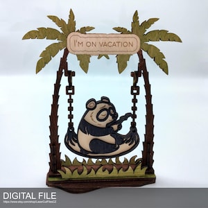 May include: Wooden panda bear on a swing, with palm trees and the text "I'M ON VACATION". The panda is black and white, and the palm trees are green and brown. The base is brown with green grass.