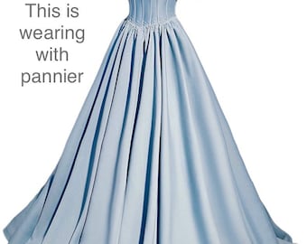 May include: A light blue ball gown with a sweetheart neckline and puff sleeves. The dress has a fitted bodice and a full skirt.