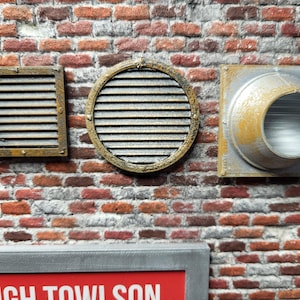 May include: Three different metal vent covers mounted on a brick wall. The vent covers are rusty and have a distressed look. The vent covers are square, round, and circular.