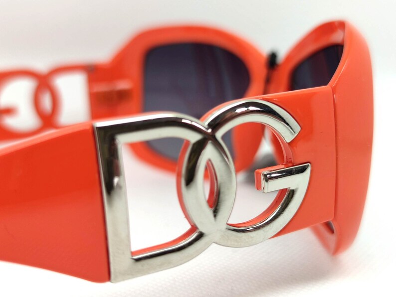 May include: Orange sunglasses with a silver DG logo on the front.