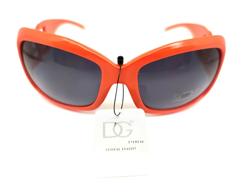 May include: Orange plastic sunglasses with dark lenses and a black tag that says "DG Eyewear Official Quality".
