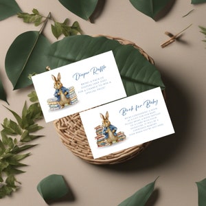 May include: Two white cards with blue text and illustrations of Peter Rabbit. The first card says "Diaper Raffle" and the second card says "Book for Baby".