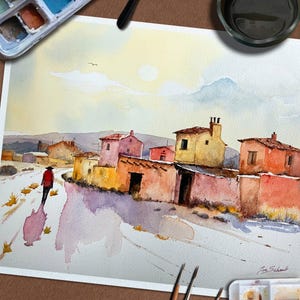May include: Watercolour painting depicting a village scene with vibrant buildings and a figure in a red coat on a path. The artwork uses warm colours, such as yellows, oranges, and pinks, with a bright sky and a watercolour palette.