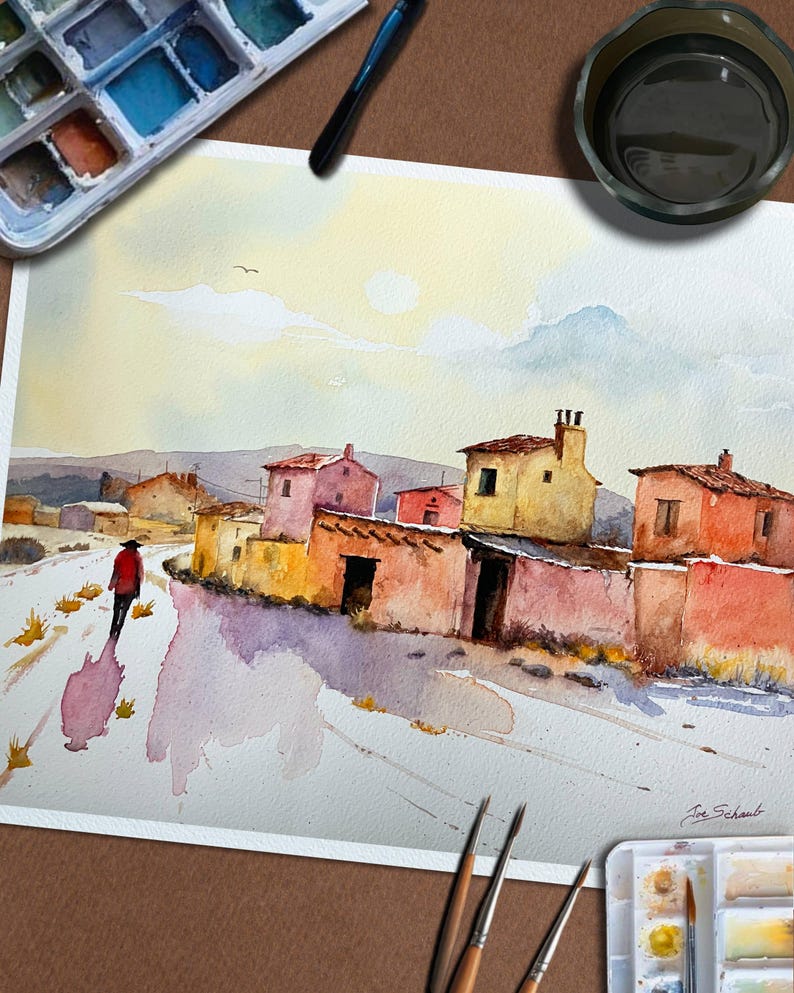 May include: Watercolour painting depicting a village scene with vibrant buildings and a figure in a red coat on a path. The artwork uses warm colours, such as yellows, oranges, and pinks, with a bright sky and a watercolour palette.