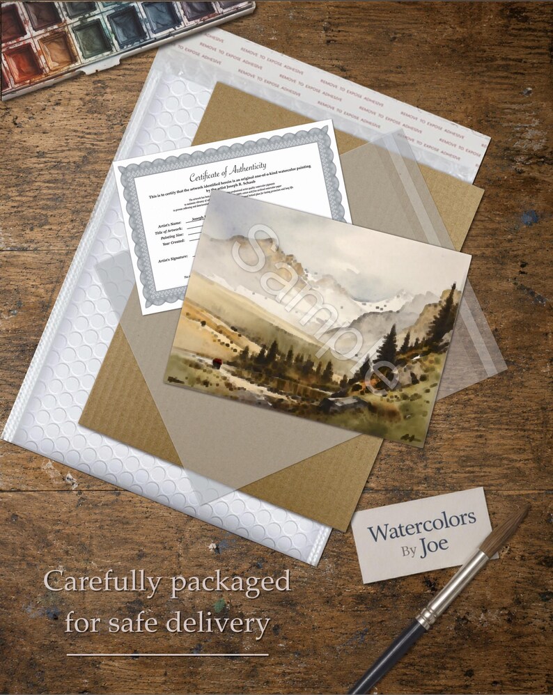 May include: A watercolor landscape painting of a mountain range with pine trees and a small stream, accompanied by a Certificate of Authenticity, a white bubble mailer, a brown cardboard backing, and a business card labeled Watercolors By Joe.