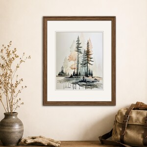 May include: A framed watercolor painting depicting a forest scene with tall pine trees in shades of dark gray and muted orange. The artwork is set within a white mat and a dark brown wooden frame, showcasing a landscape with reflections on water.