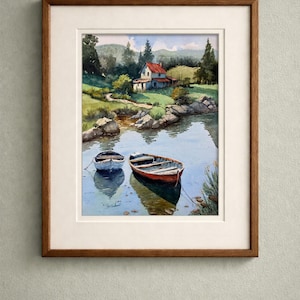 May include: Watercolor painting of a serene lake scene with two small boats. A red-roofed house sits on the shore, surrounded by lush greenery and trees. The artwork is framed in a wooden frame with a white mat.