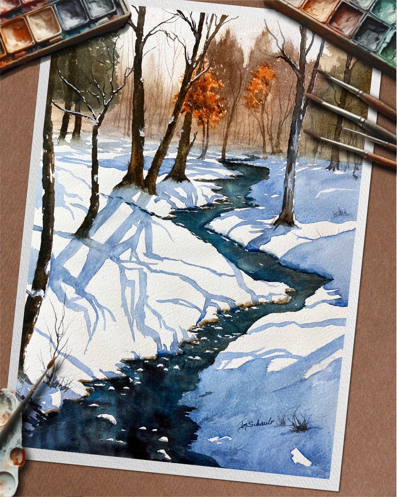 May include: Watercolor painting of a winter landscape with a stream. The artwork features a snow-covered scene with bare trees and a winding blue stream. The painting includes a palette of watercolors and paintbrushes.