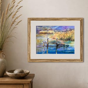 Puede incluir: Una pintura de acuarela enmarcada que representa un muelle de madera que se extiende hacia un cuerpo de agua tranquilo con aves posadas en los postes. La escena presenta juncos dorados al fondo bajo un cielo azul profundo y violeta.