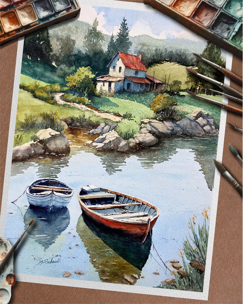 May include: Watercolor painting of a serene landscape featuring a house with a red roof, a lake, and two small boats. The artwork showcases a natural setting with trees, rocks, and reflections in the water. Paintbrushes and a palette are visible.