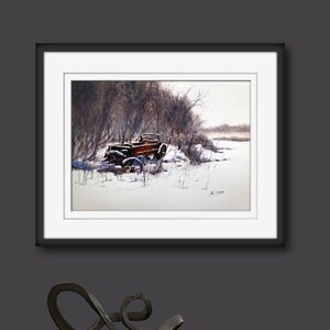 May include: Watercolour painting of a vintage red truck in a snowy landscape. The truck is partially covered in snow, surrounded by bare trees and a snow-covered field. The artwork is framed in a black frame with a white mount.