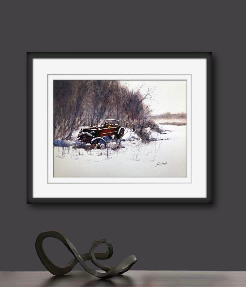 May include: Watercolour painting of a vintage red truck in a snowy landscape. The truck is partially covered in snow, surrounded by bare trees and a snow-covered field. The artwork is framed in a black frame with a white mount.