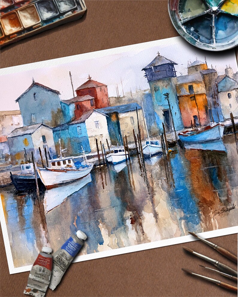 May include: Watercolor painting of a harbor scene with boats and buildings in shades of blue, orange, and white. The artwork features reflections in the water and is signed by the artist. Paint tubes and brushes are visible in the image.