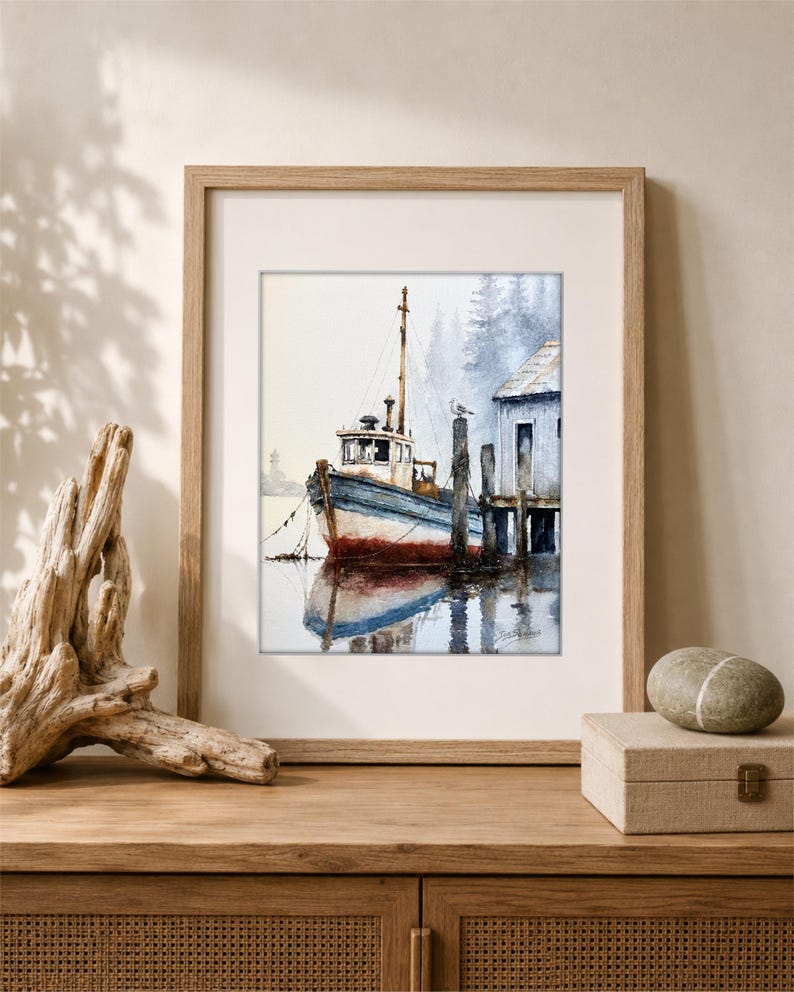 May include: A framed watercolor painting depicting a weathered blue and white fishing boat docked at a wooden pier. The scene includes a small building, a lone bird perched on a post, and a misty forest background, all rendered in soft tones.