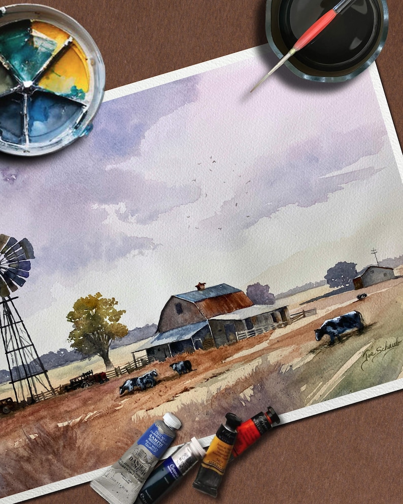 May include: Watercolor painting of a rural farm scene with a barn, windmill, and cows grazing in a field. The artwork features a muted color palette with shades of brown, blue, and purple. Paint tubes and a palette are visible.