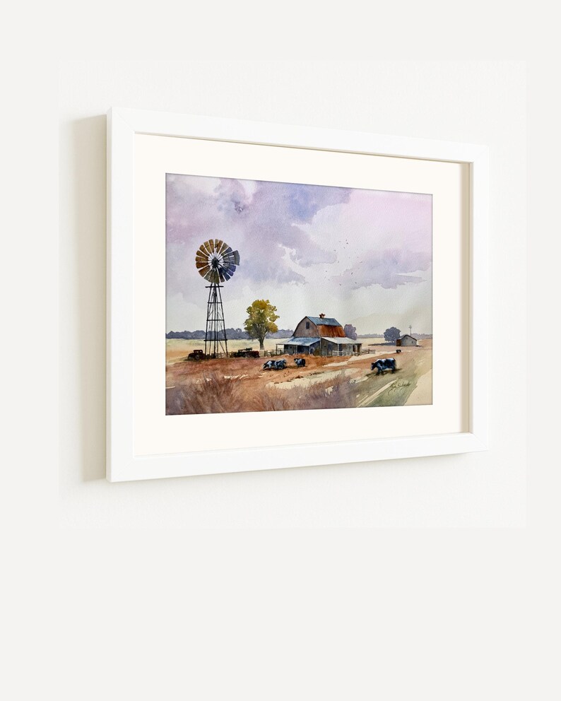 May include: Watercolor painting of a rural landscape featuring a windmill, barn, and fields under a cloudy sky. The artwork is framed in a white border, showcasing a serene countryside scene with muted colors and a vintage aesthetic.