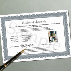 May include: A white Certificate of Authenticity document with a grey decorative border, featuring the text 'Certificate of Authenticity', artist name 'Joseph R. Schaub', title 'The Garden Table', size '11 x 14 inches', and a year '2026'. A black fountain pen lies across the bottom left corner.