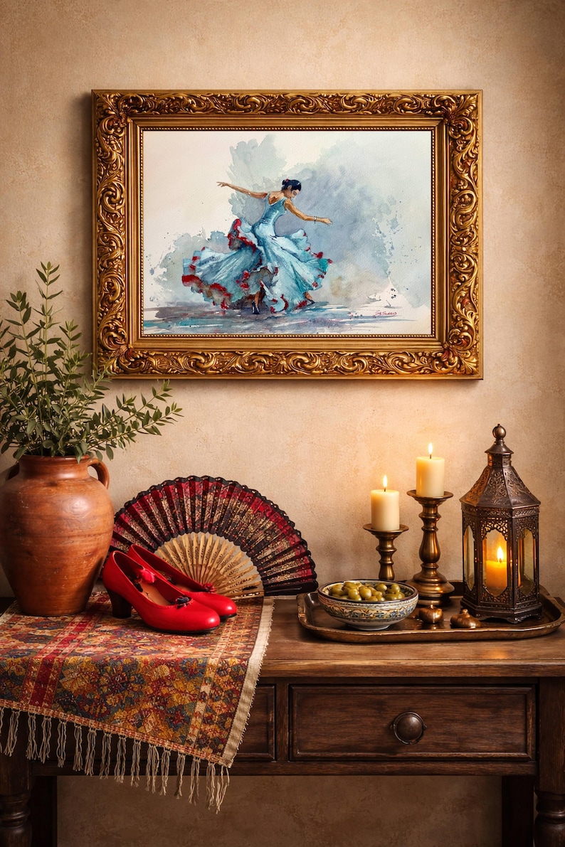 May include: A framed watercolor painting of a dancer in a flowing blue dress with red accents. The painting hangs above a table with red heels, a fan, candles, and a decorative lantern. A vase with greenery is on the left.