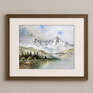 May include: A framed watercolor painting depicting a landscape with snow-capped mountain peaks, a calm lake in the foreground, and a dense forest of dark green pine trees along the shoreline under a cloudy sky with patches of blue.
