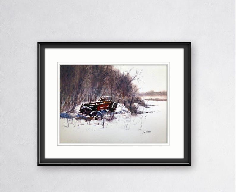 May include: Watercolour painting of a vintage red and black car in a snowy landscape. The car is partially covered in snow, with bare trees in the background. The artwork is framed in a black frame with a white mount.