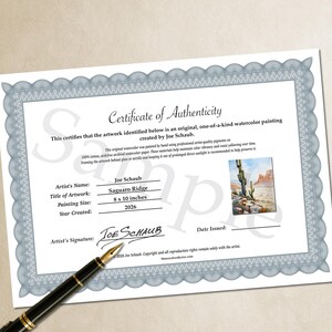 May include: A Certificate of Authenticity for a watercolor painting titled Saguaro Ridge by Joe Schaub, dated 2026, measuring 8 x 10 inches. The document features a blue decorative border, a small image of the artwork, and a black fountain pen.