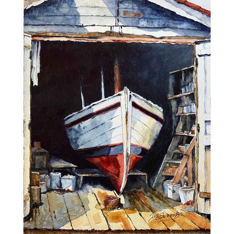 May include: A watercolor painting depicting a white boat with a red hull and dark blue trim resting inside a dark wooden boathouse. The scene features a wooden floor, shelves with various containers, and the signature Joe Schaub in the corner.
