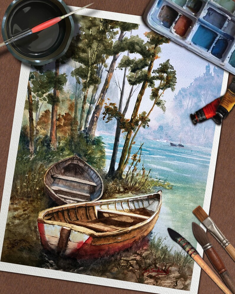 Op de afbeelding: Waterverfschilderij van een serene oeversc&egrave;ne met twee houten boten. Het kunstwerk toont een levendig kleurenpalet van blauw, groen en bruin, met bomen langs de oever. Penselen, verftubes en een palet omringen het schilderij.