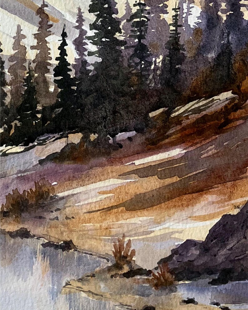May include: Watercolor painting of a mountain landscape with a forest of dark green trees. The foreground features a river or lake with a rocky shoreline. The sky is a mix of light and dark colors.
