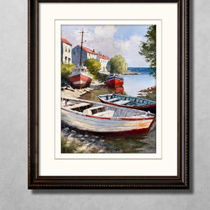May include: Watercolor painting of several small boats resting on a shoreline. The boats are painted in red and white, with a few blue boats in the background. Buildings with red roofs and a blue sky complete the coastal scene, framed in a dark wood frame.