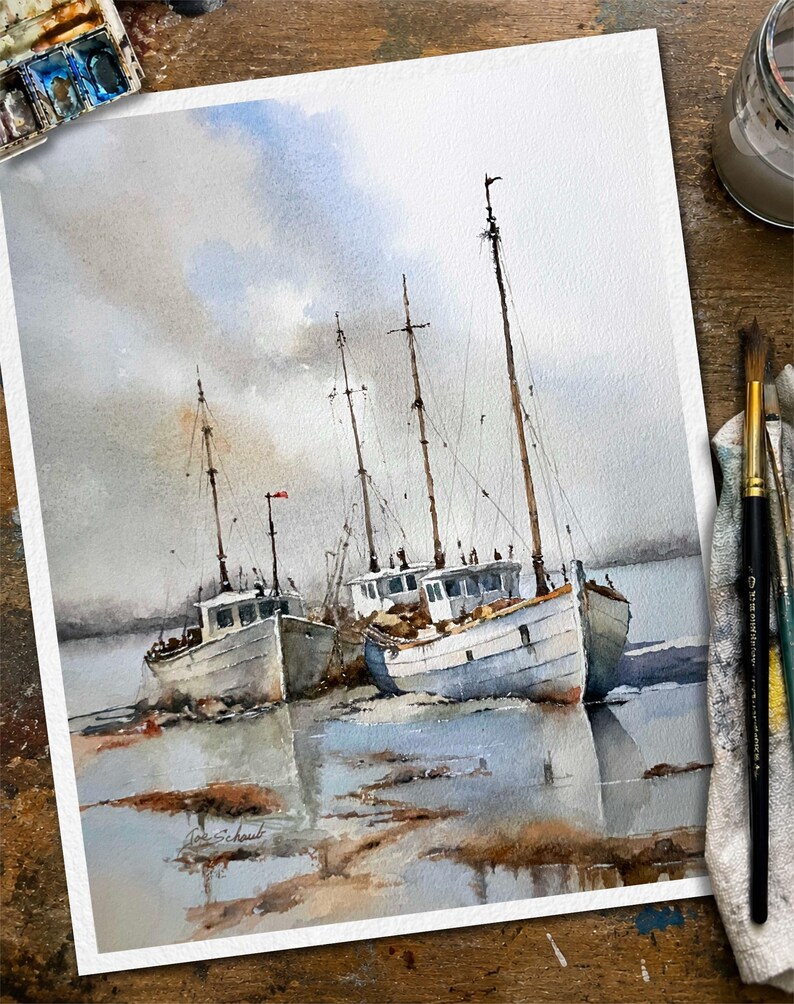 May include: A watercolor painting on paper depicting two white fishing boats moored in shallow water under a cloudy sky. The vessels feature tall masts and weathered hulls, with soft reflections visible in the water below. The artist signature is visible.
