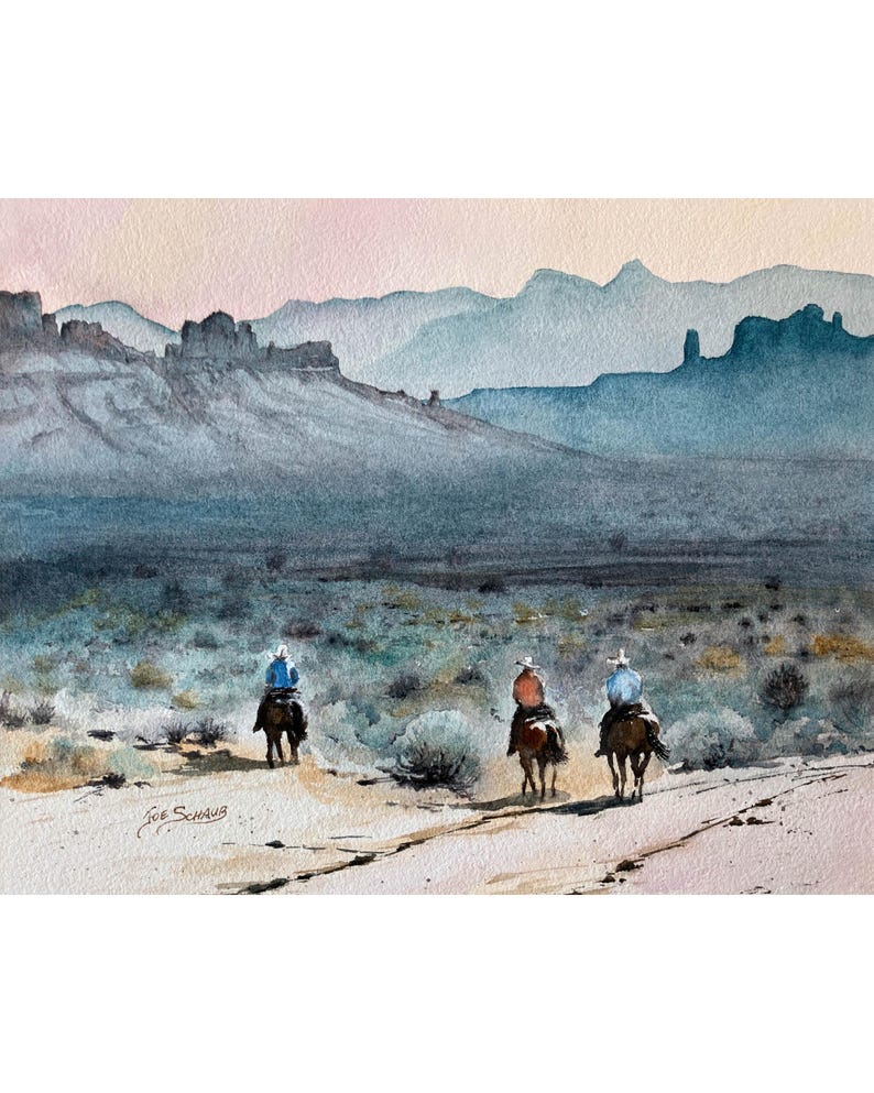May include: Watercolour painting depicting three cowboys on horseback, traversing a dirt track. The backdrop showcases a mountain range in varying shades of blue and a pink and beige sky. The artist's signature is visible.